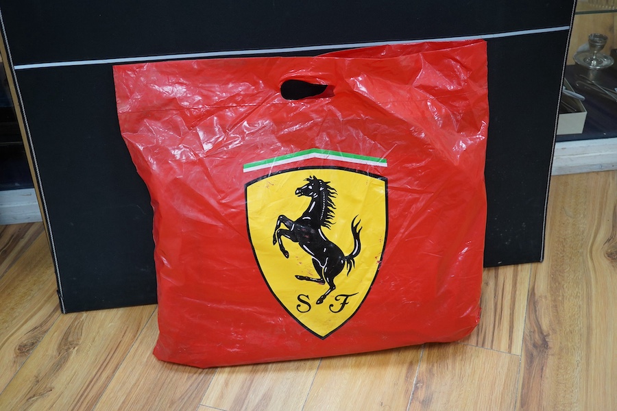 Two official Ferrari branded bags; a backpack and a duffle bag, both new with tags, both contained within an original Ferrari plastic bag dated 2002. Condition - good.